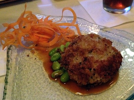 a crab cake with soy beans and shredded carrot