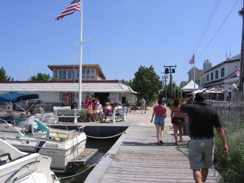 People walking on a dock at a marina.