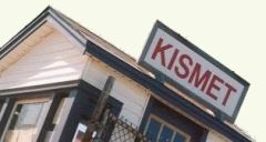 A small building with a sign on top that reads "Kismet"