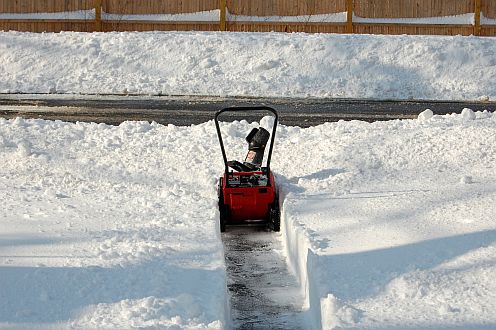 A small snowblower cutting through deep snow